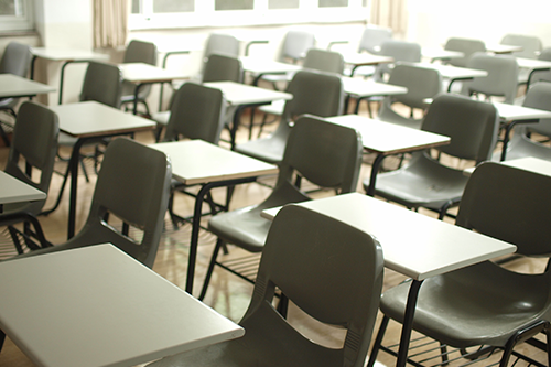 rows of empty desks in a classroom